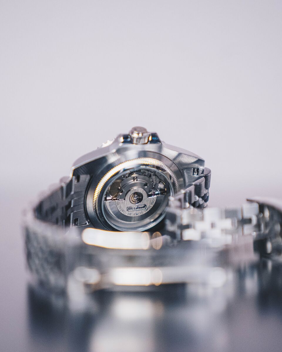 Macro of an exhibition caseback with the automatic movement and rotor visible through the sapphire.
