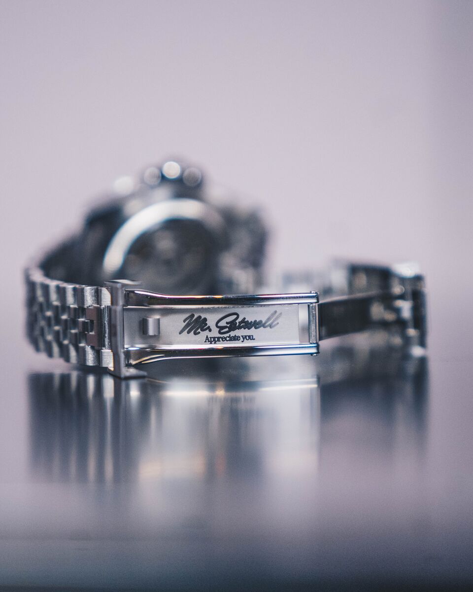 Macro of a bracelet clasp engraved Mr. Eatwell, Appreciate you.
